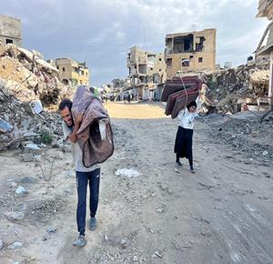 نازحون في منطقة الزنة شرق خان يونس يحاولون الحصول على ما استطاعوا انتشاله من بين أنقاض منازلهم المدمرة